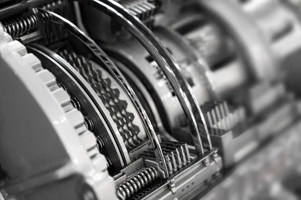 Primer plano de la parte interior de una transmisión con discos y resortes, típicas refacciones de transmisiones automáticas para reparación y mantenimiento.
