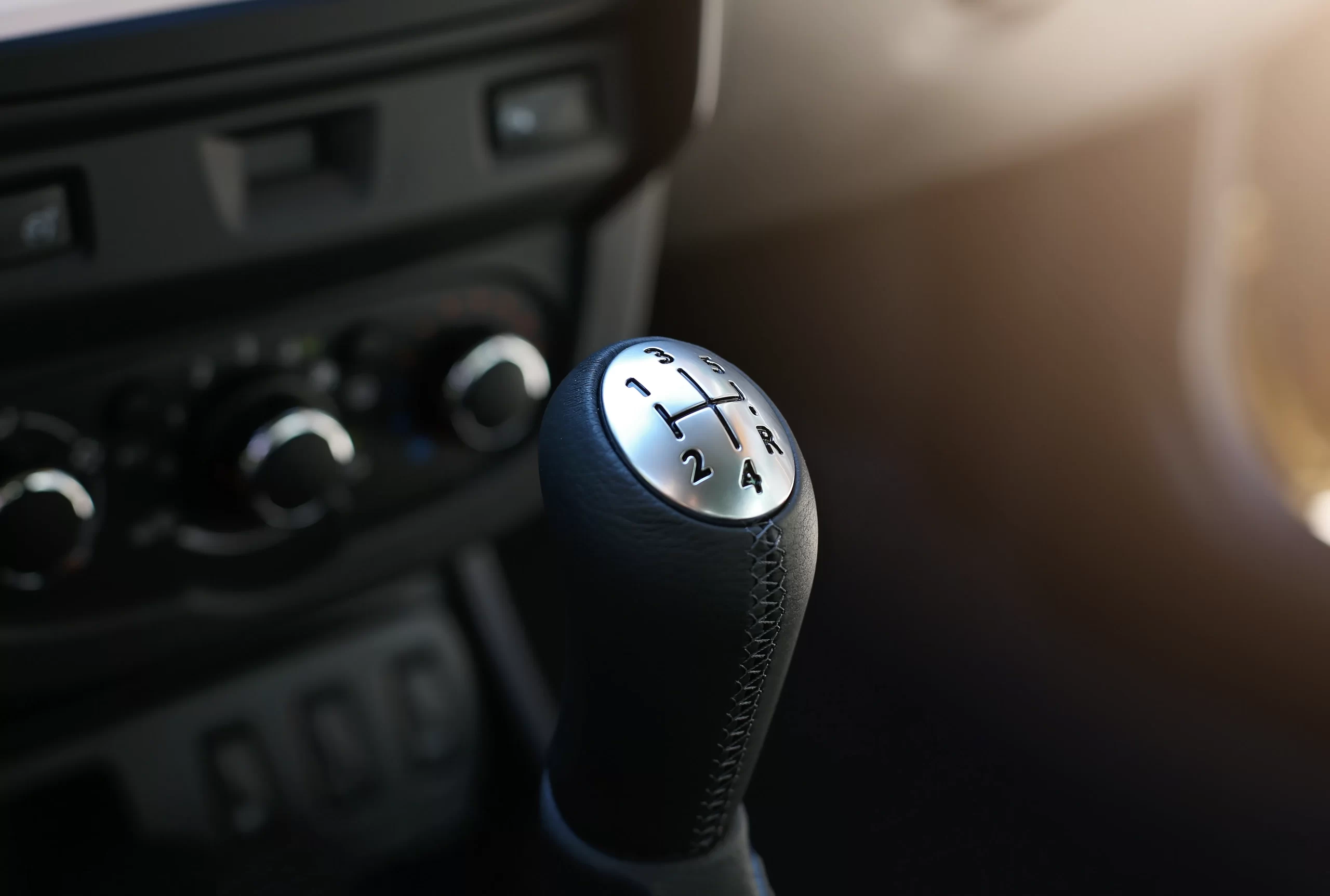 Vista cercana de una palanca de cambios manual con el patrón de marchas típico de una transmisión estándar