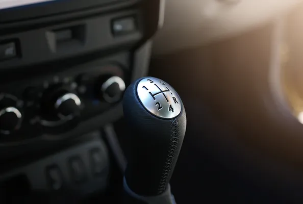 Perilla de la palanca de caja de velocidades estándar con patrón de seis marchas y reversa, con costuras de cuero a su alrededor.