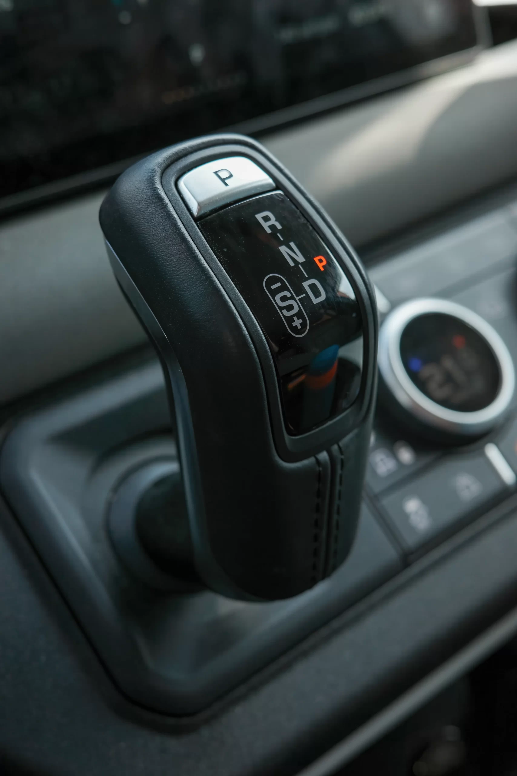 Palanca de cambios en posición de estacionamiento (P), con las letras P R N D que indican una transmisión automática moderna